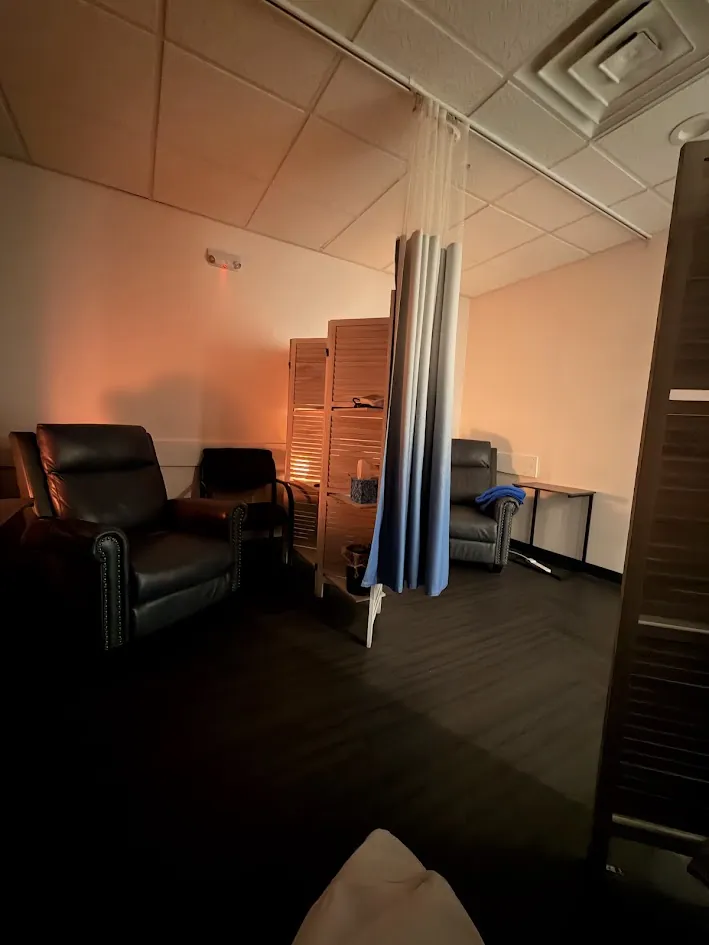 Inside the Bridgewater office: leather recliners in a softly lit treatment room, separated by a privacy curtain and wooden screens.