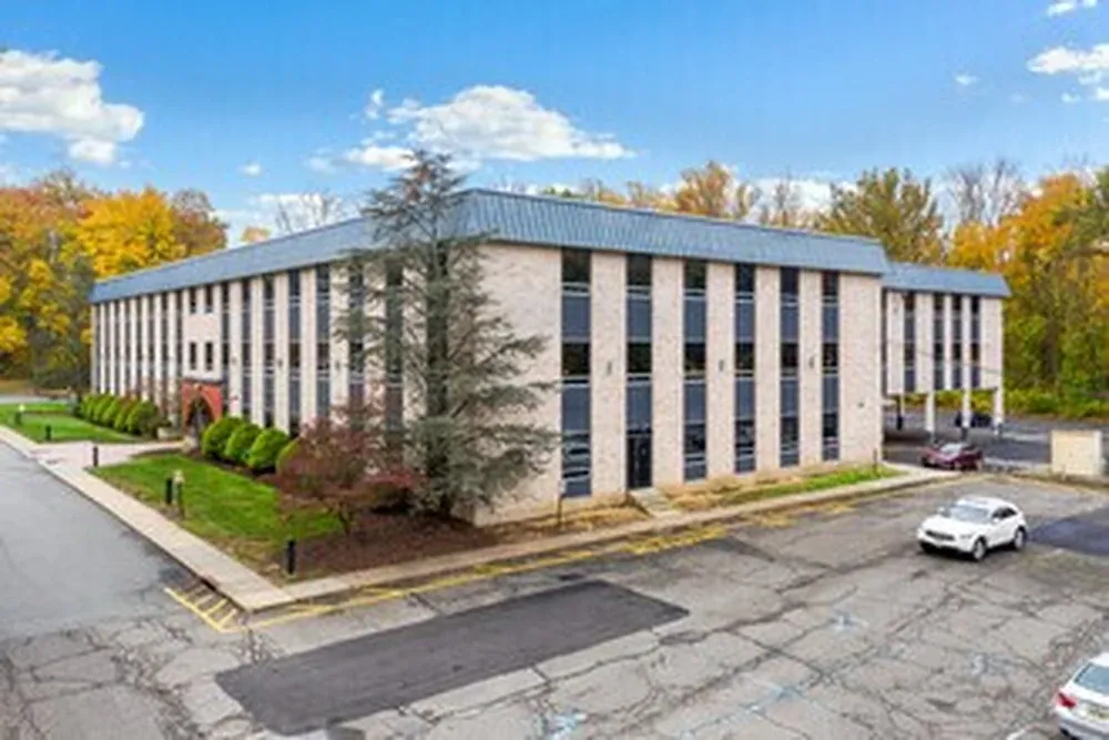 The three-story brick office building at 25 Lindsley Drive in Morristown, with parking out front.